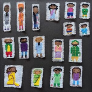seventeen cross stitched people dressed in primarily traditional Indian clothing